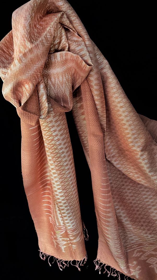 From Surin province in Thailand, this luxurious shawl is 100% handwoven silk. The dyes are natural from leaves, bark and flowers, creating color that is rich but subtle: rose, pink, hints of green and ivory.