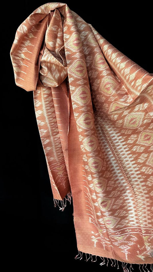 From Surin province in Thailand, this luxurious shawl is 100% handwoven silk. The dyes are natural from leaves, bark and flowers, creating color that is rich but subtle: rose, pink, hints of green and ivory